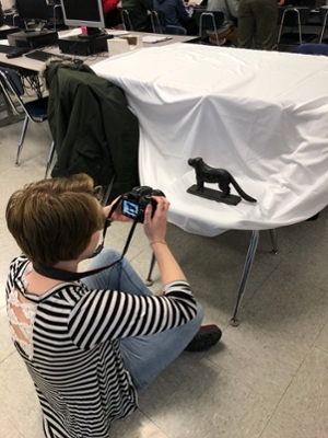 SIUE student Lillian Stevens photographs an artifact brought in by a Liberty Middle School student.
