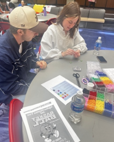 2 students create bracelets