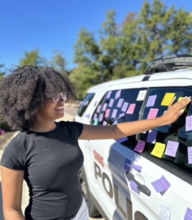 Student putting a post it on the SIUE PD cruiser