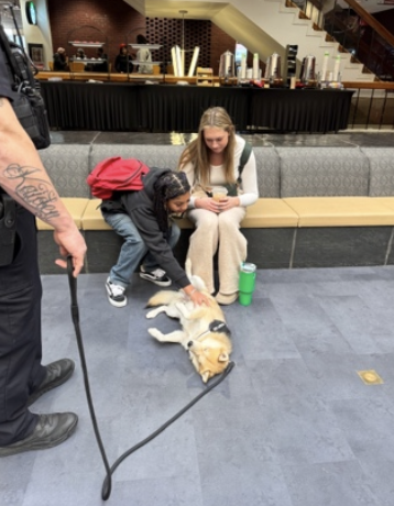 2 students interact with SIUE PD dog, Chase