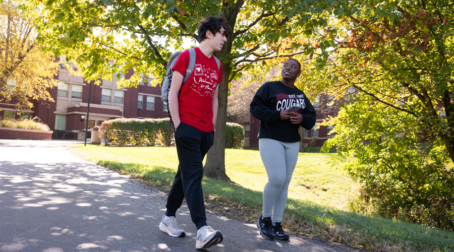 Two Students walking near a residence hall.
