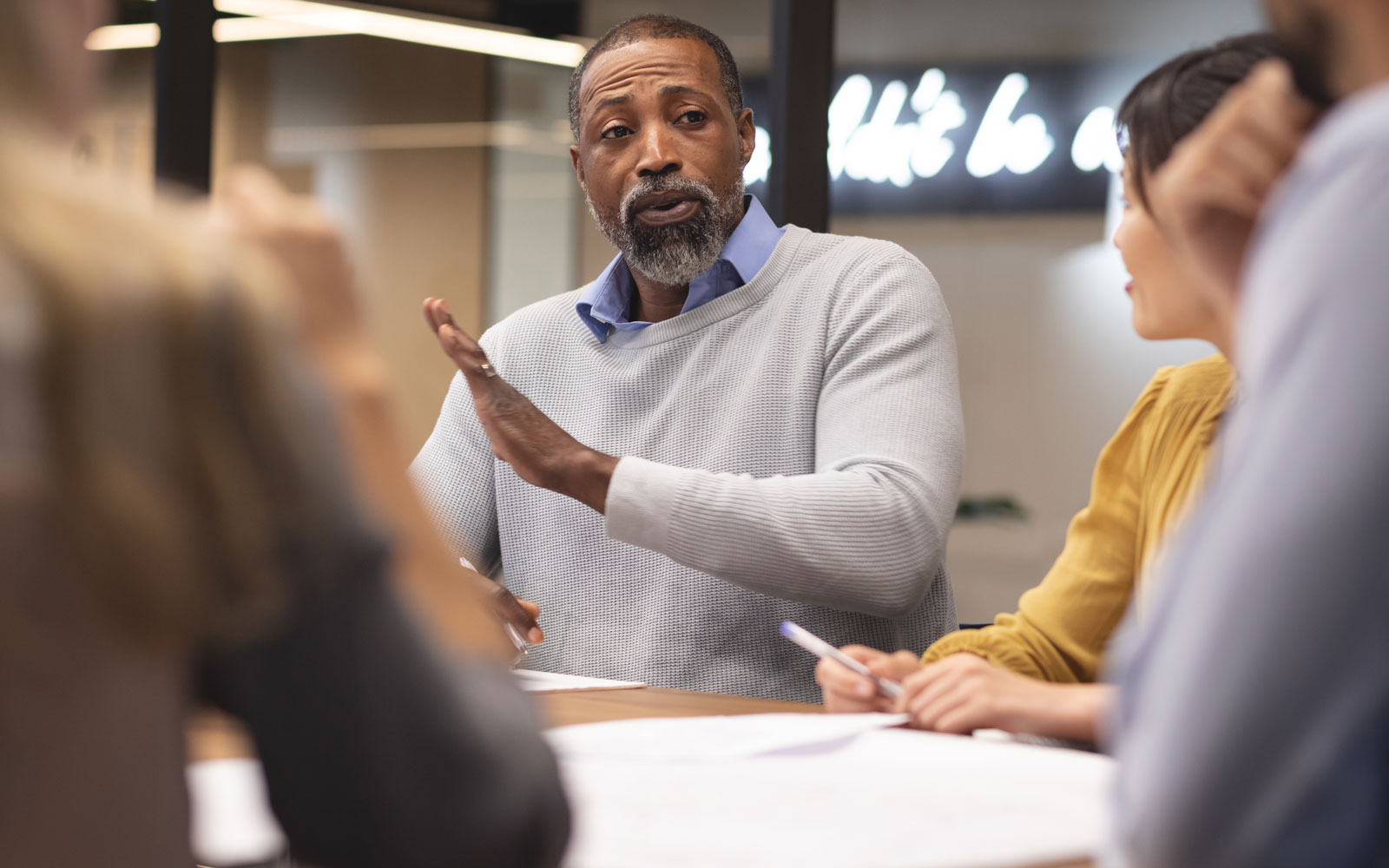 mature man at conference table with coworkers