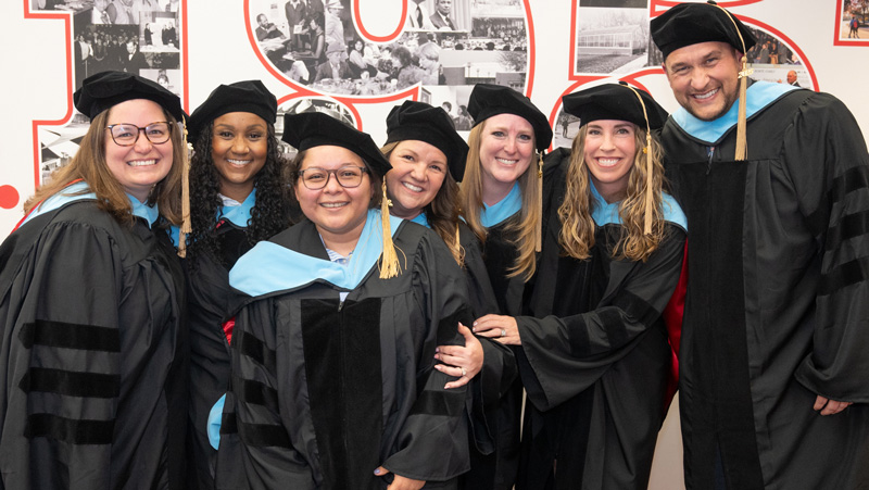 group of doctoral graduates in cap and gown