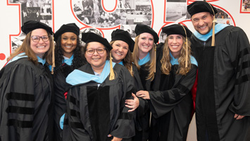 group of doctoral graduates in cap and gown