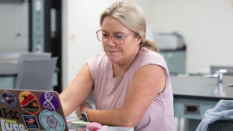 woman working on a laptop at a lab table