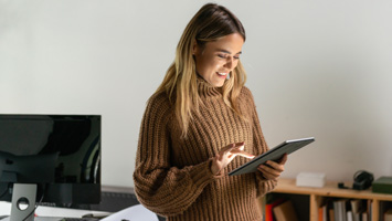 smiling woman looking at tablet