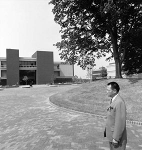 Gyo Obata standing in the center of campus with Lovejoy Library in the background.