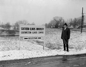 Vice President Harold W. See, standing near a newly-erected directional sign, moved his administrative offices to campus on December 18, 1959.