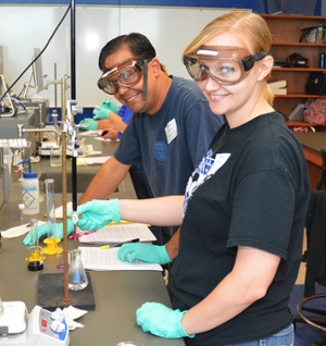 Chris Levrault, chemistry teacher at Mascoutah High School, poses with Erika Knolhoff, chemistry teacher at Greenville High School, as they do a redox titration.