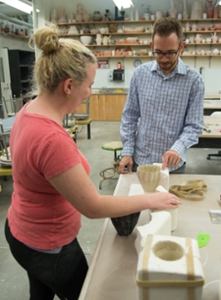Joe Page, assistant professor of ceramics in the SIUE Department of Art and Design works with graduate student Caitlin McDonald.