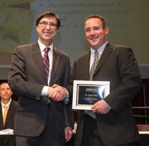 School of Engineering Interim Dean Cem Karacal presents Dr. Ryan Fries, associate professor of civil engineering, with the outstanding researcher award.