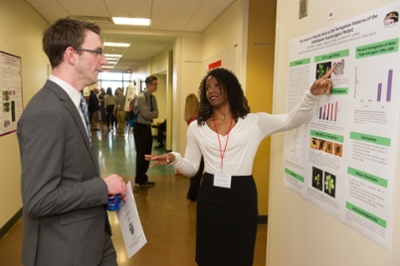 SIUE senior Jhunnelle Walters, a biological sciences major, presents her research to fellow student Luke Brown.