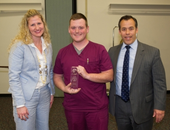 Student Joshua Welborn, (L) winner of the student table clinic competition receives his award from ADA/DENTSPLY representatives.