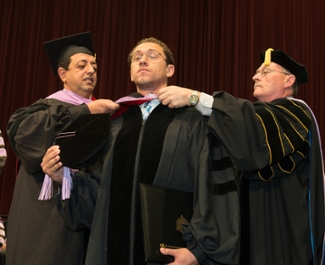 Peter Girgis is hooded during the ceremony by his father, Dr. Philip Girgis (L), a 1990 alum of the SIU School of Dental Medicine.
