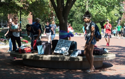 SIUE students stopped between classes to read the stories included on the backpacks on display at the Send Silence Packing event.