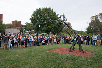 A crowd gathers to view one of the pieces featured in the 2016 Sculpture Walk at SIUE.