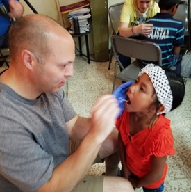 SIU School of Dental Medicine Interim Associate Dean for Academic Affairs Dr. Kenneth Rawson provides care to a young girl in Costa Rica.