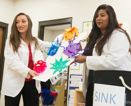 Megan Stafford and Veebha Gowda, first-year students in the SIUE School of Pharmacy, interact with students in East St. Louis during their hand washing presentation.