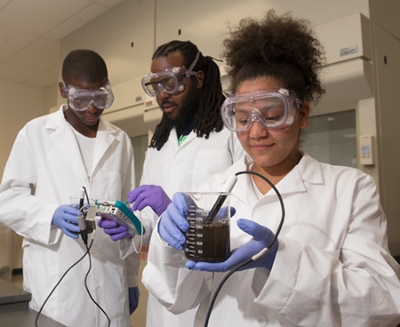 Digital East St. Louis instructor Johnathan Tate (middle) leads soil testing in an SIUE science laboratory with high school students Da’Quain White (L) and Alyssa Gines (R).