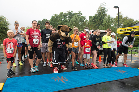 Runners take their places at the starting line alongside SIUE’s Eddie the Cougar during the inaugural Cougars Unleashed Homecoming Run.