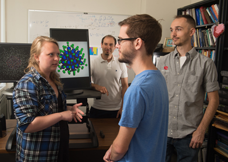 Edward Ackad, PhD, (back) associate professor of physics at SIUE, observes as student researchers discuss their project, including (L-R) Valerie Becker, Jeremy Thurston, and Kasey Barrington.