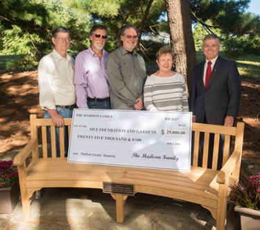 (L-R) Paul, Curt and Roger Madison, The Gardens Advisory Board Chair Marian Smithson, and SIUE Chancellor Randy Pembrook stand alongside the curved memorial bench which honors the late Eldon, Grace and Carol Madison.