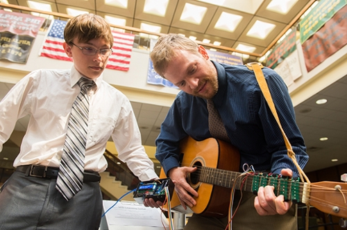 Nicholas Carter, of St. Charles, Mo., and Dan Ashbaugh, of Altamont, demonstrate the usability of their team's LED Learning Guitar.