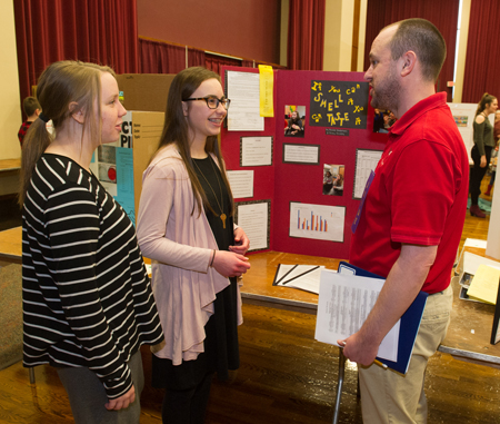 Rachel Anderson (L) and Riley Dickey (middle) spoke about their project with Science and Engineering Research Challenge volunteer judge Thad Meeks, PhD, SIUE associate professor of psychology.