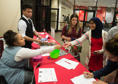 (L-R) SIUE public relations students Daniel Nosce and Lauryn Fox welcomed Aiman Farooqui and other students to International Studies Day.
