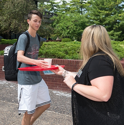 Cole Wendler, of Troy, happily accepts a cup of lemonade as he walks to class.