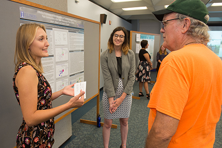 Julia Allison, a rising senior from the University of Illinois Urbana-Champaign, and Sarah Klush, a rising sophomore from Hofstra University in Hempstead, N.Y., explain their research at the REU Symposium.
