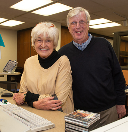 Ann and Richard Moss smile behind Lovejoy Library’s circulation desk, the place they first met more than 50 years ago.