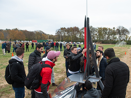 Members of the news student organization, Cougar Rockets, position their 63-inch rocket on the launch platform.
