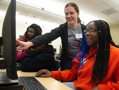 Rachel Koenig, a senior studying computer science at SIUE, assists Emani Murphy, from Alton High School, during SheCode.
