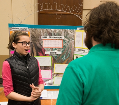 A SERC participant presents her electromagnetism research to a judge. 