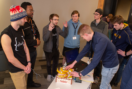 Judge Mitch Zurliene tries out Behemoth, the Best Overall project, while team members (L-R) Blaise Willoughby, David Blackburn, Laban Colyott, Kyle Fricilone, Nicholas Carter and Samuel Feye look on.