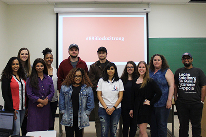 Media campaigns students creating the #89BlocksStrong campaign stand alongside community organizer Jessica Wernli (front far left) and Dr. Suman Mishra (front second from left).