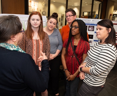 A team of social work master’s candidates discuss their research on the effect of child behavior related to parental stress during the Graduate School Research Symposium.
