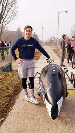 Human Powered Vehicle driver Anthony Kindle stands alongside his team’s creation.