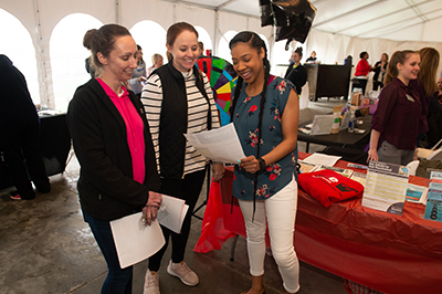Third-year School of Pharmacy student Deja Finley shares educational information with event participants Mary Schmitt and Jamie Kuhn, of Freeburg.