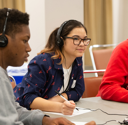 Edwardsville High School sophomore Elannore Bester listens intently to a student’s digital storytelling creation during the Conversation Toward a Brighter Future 2.0 Summit.