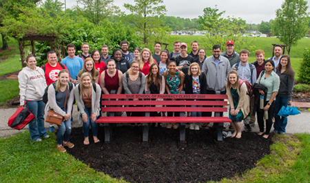 The School of Pharmacy Class of 2020 surrounds the bench made of recycled bottle caps that they donated to the School and had installed by the Medicinal Garden.