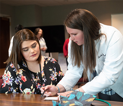 SOP Class of 2019’s Nicole Wheeler explains blood pressure results to a patient.