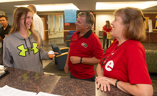 SIUE Chancellor Randy Pembrook and his wife, Mary Jo, offer jovial greetings and a cupcake to freshman Lynnae Thomas, of Taylorville, during University Housing’s House Calls event.