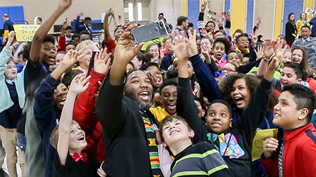 SIUE alumnus Tron Young, EdD, celebrates being named 2020 Illinois Middle School Principal of the Year with students at Joseph Arthur Middle School.