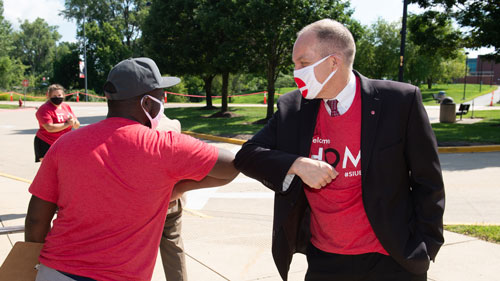 SIU President Daniel Mahoney (right) greets an SIUE student with an elbow bump during the first of five Move-In Days.