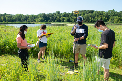 While at the Watershed Nature Center in Edwardsville, geoscholars Anu Khadka, Alice Yerby, Logan Pelo and Jesus Sanchez use GPS to record the locations of reference points that the drone uses.
