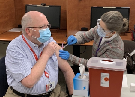 SIU School of Dental Medicine Dean Bruce Rotter, DMD, receives the first dose of the Moderna vaccine during a vaccination clinic on the Alton campus.