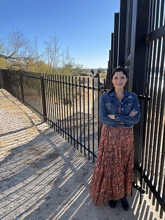 Standing alongside the U.S.-Mexico border fence is SIUE’s Adriana E. Martinez, PhD.