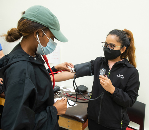 Students perform heart and blood pressure screening prior to a graded exercise test to measure cardiovascular health.